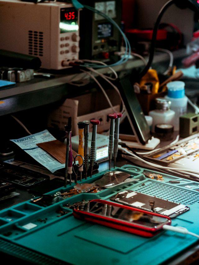 Banco de trabajo con destornilladores de precisión y herramientas para reparar equipos